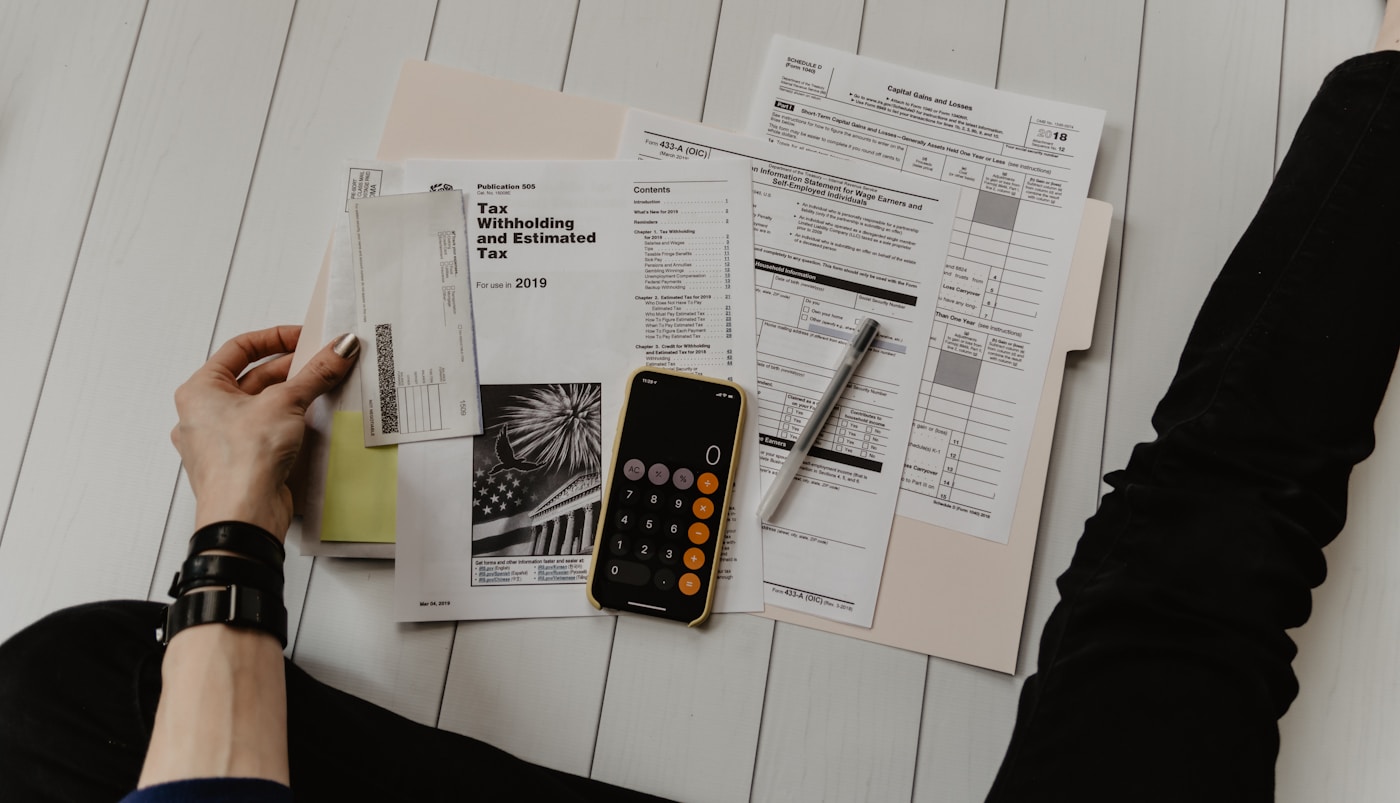 Budget notebook open beside a calculator for monthly expense planning