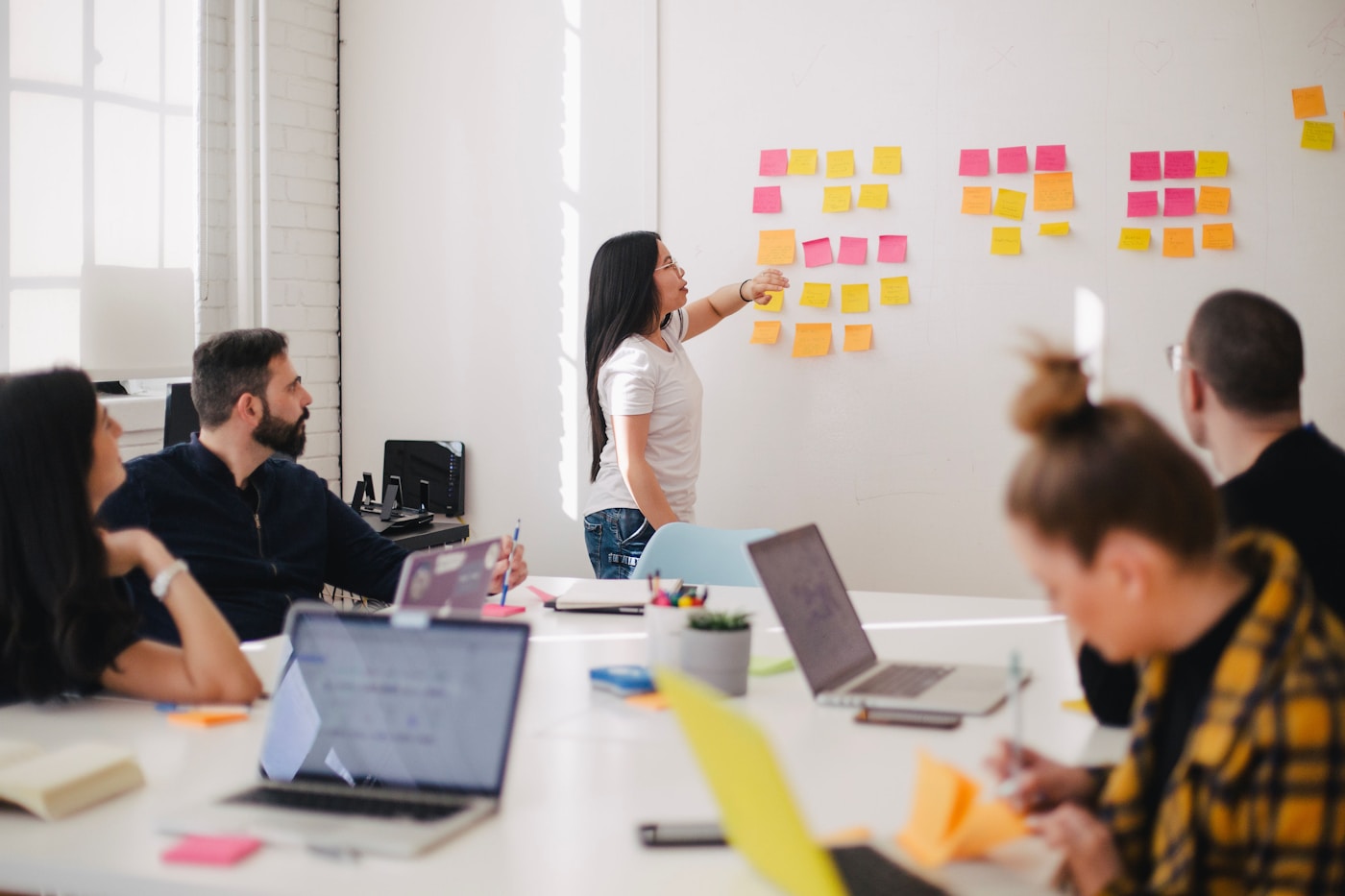 Team planning monthly budget flows on a whiteboard in an office