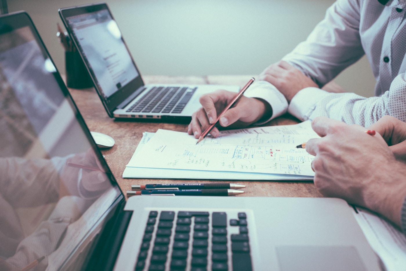 Small business owner organising receipts and expenses at a desk with laptop